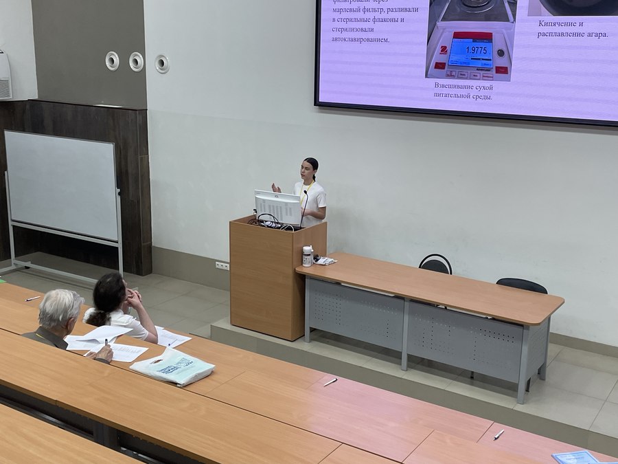 Mariia Miroshnik presenting her research on stage at a school science conference